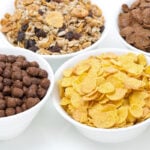 Four white bowls filled with different cereals — cereals application